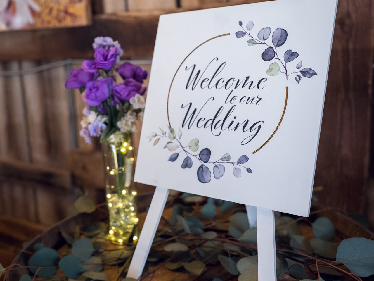 Beautiful wedding welcome sign with purple flowers and elegant lettering, perfect for rustic decor.