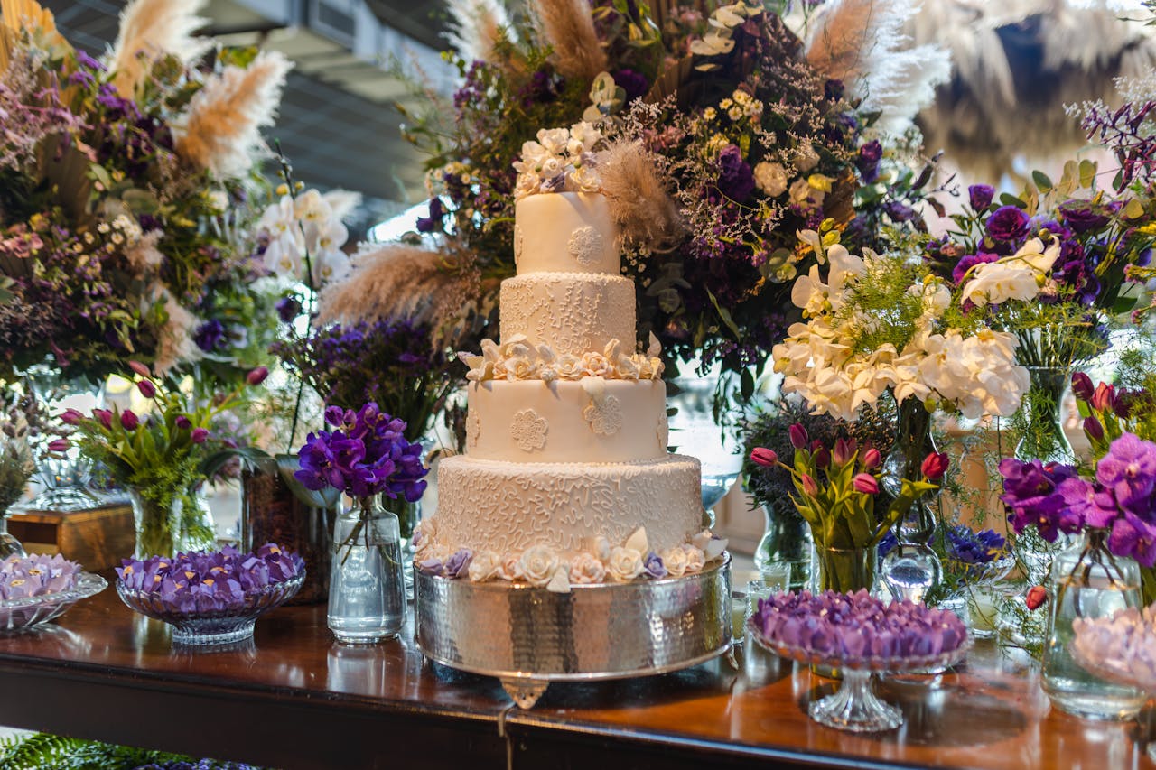 Luxurious white wedding cake surrounded by vibrant floral arrangements, perfect for upscale celebrations.